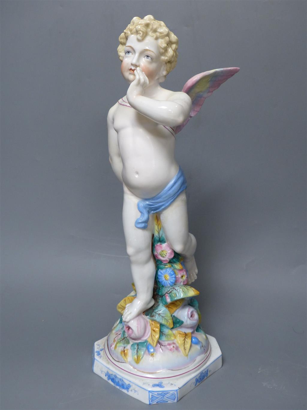 A large late 19th century French porcelain figure of Cupid, an English bone china cherub vase and a similar sweetmeat dish, tallest 3